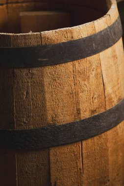 Düşük ışıklandırmalı metal halkalı ahşap bir fıçıya yakın çekim.