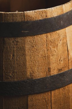 Düşük ışıklandırmalı metal halkalı ahşap bir fıçıya yakın çekim.