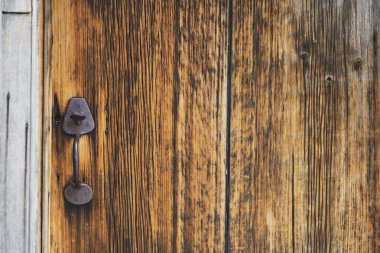 Yıpranmış ahşap kapı, sıcak doğal tonlarda antika demir saplı..