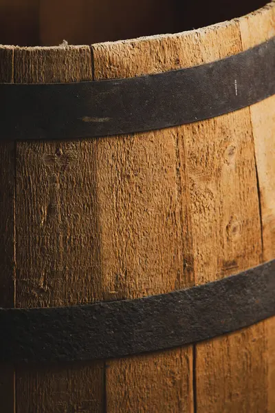 Düşük ışıklandırmalı metal halkalı ahşap bir fıçıya yakın çekim.