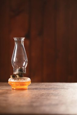 Koyu ahşap kaplamalı ahşap masa üzerinde klasik bir gaz lambası..