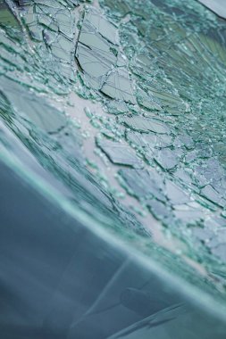 Arabanın ön camındaki kırık güvenlik camının detaylı görüntüsü. Kırık cam desenleri merkezi darbe noktasından yayılıyor..