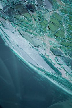 Arabanın ön camındaki kırık güvenlik camının detaylı görüntüsü. Kırık cam desenleri merkezi darbe noktasından yayılıyor..