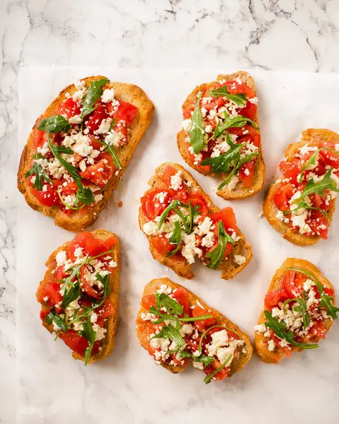 Süzme peynir, domates ve mermer arka planda taze maydanoz. Geleneksel İtalyan bruschetta.