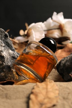 Masada bir şişe ve bir bardak parfüm.