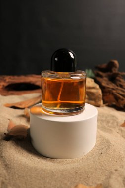 Arka planda bir kumun üzerindeki parfüm şişesi