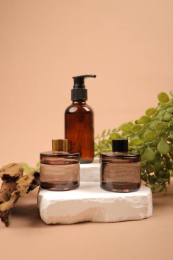 Doğal kozmetik ürünleri ve bej arka planda doğal yağ şişeleri