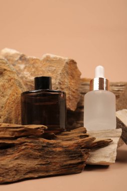 Temel yağ şişesi ve beyaz arka planda taze kahverengi yapraklar.