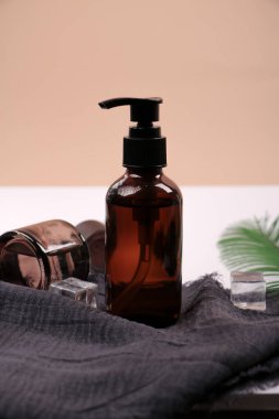 Kozmetik şişeleri ve havluyla masada bir şişe.