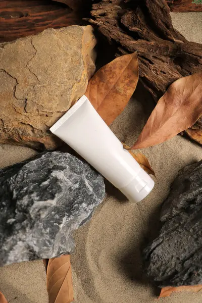 Arka planda bir kumun üzerindeki parfüm şişesi