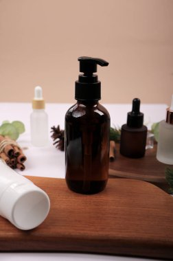 Kaliteli yağ şişeleri ve taze kozmetik ürünleri bulanık arka plana karşı ahşap masada.