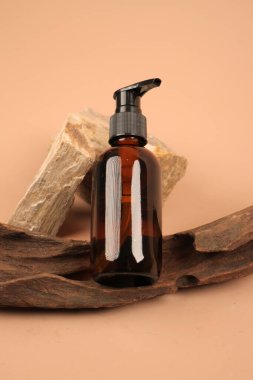 Beyaz arka planda kozmetik yağlı ve kuru yapraklı bir şişe. Spa ve vücut bakımı kavramı