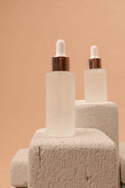 Bej arka planda krem ve serum olan kozmetik şişeler