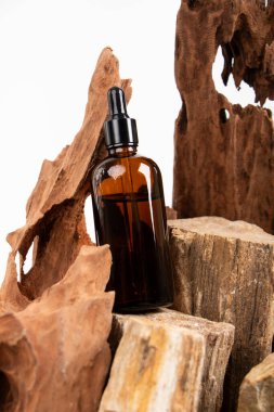 Kahverengi kozmetik yağ şişesi ve ahşap arka planda bir şişe..