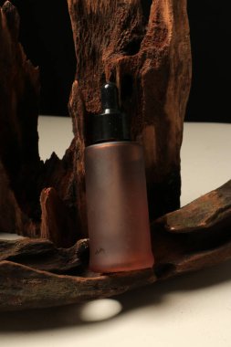 Doğal kozmetik ürünü, serum şişesi ve tahta arka planda cam. Doğal ürün, cilt bakımı.