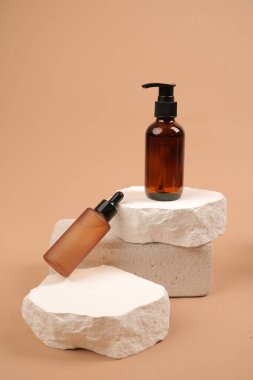 Doğal kozmetik ürünleri şişesi ve bej arka planda doğal sabun.