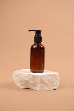 Bej arka planda doğal kozmetik ürünü şişesi