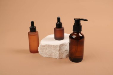 Doğal kremalı kozmetik şişeleri ve bej arka planda doğal etiket