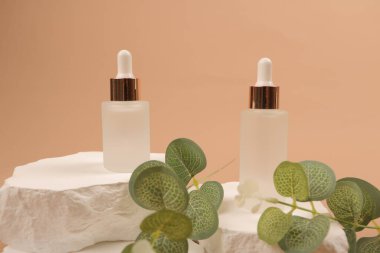 Kozmetik şişe, serum ya da yüz kremi yapraklı beyaz kağıt üzerinde. Cilt bakım ve organik ürün konsepti. Doğal kozmetik ürünleri. Doğal ürün, güzellik, vücut