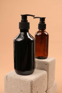 Siyah arka planda bir şişe ve bir bardak kozmetik..