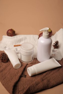 Bej arka planda kozmetik krem ve havlu.