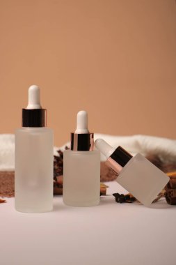 Siyah arka planda kozmetik krem, serum ve yüz kremi şişeleri