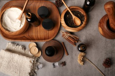 Farklı türde doğal kozmetik ürünleri, spa ürünleri ve vücut bakımı için aksesuarları olan düz ahşap masa.