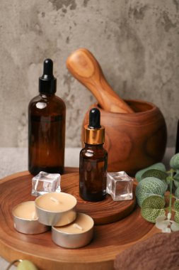 Temel yağ şişesi, ahşap masa, spa ve hafif arka planda vücut bakımı bileşimi