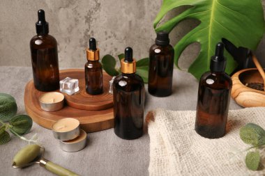 Tahta masanın üzerinde gerekli yağ ve bitkilerle farklı şişeler var.