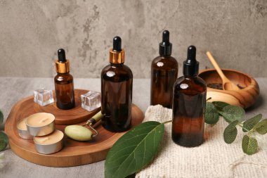 Kaliteli yağ şişeleri ve okaliptüs dalları ahşap masada.