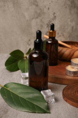 Temel yağ şişesi ve okaliptüs yapraklarıyla hafif arkaplanda bileşim