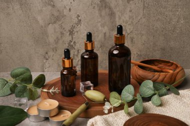 Doğal kozmetik ürünleri ile ahşap masa üzerindeki kompozisyonu gri arka planda