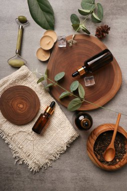 Yağ, tuz, okaliptüs dalı ve ahşap arka planda yapraklarla kaplıca bileşimi.