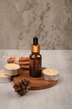 Açık gri mermer zemin üzerinde cam şişe içinde gerekli yağ ve kuru yapraklar ile bileşim