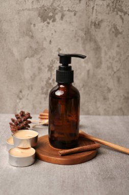 Gri masanın üzerinde gerekli yağ ve okaliptüs dalları bulunan bir kompozisyon. Metin için boşluk