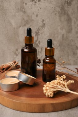 Gerekli yağlı şişeler ve ahşap arka planda taze çiçekler. Metin için boşluk