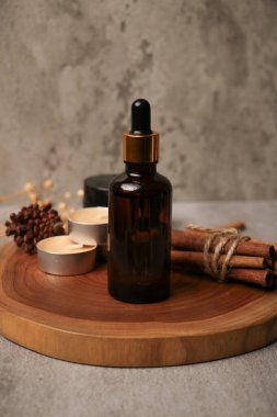 Beyaz ahşap arka planda taze kahverengi okaliptüslü cam yağ şişesi, düz. Metin için boşluk