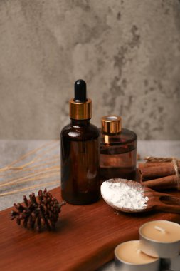 Esaslı yağ şişesi ve tarçın çubukları koyu arka planda..