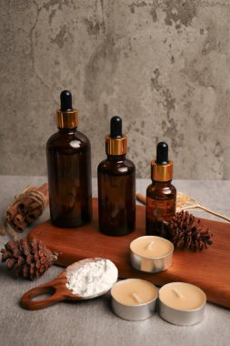 Ahşap masa üzerinde gerekli yağ şişeleri, tarçın ve kuru dallar içeren kompozisyon. Metin için boşluk