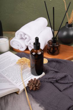 Spa ve sağlık konsepti. Doğal kozmetik ürünleri, yağ şişesi ve ahşap arka planda havlu.