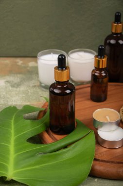 Ahşap masa üzerinde gerekli yağ ve yeşil yapraklar şişeleri, metin için yer