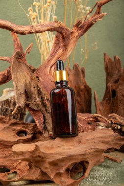 Bir şişe doğal serum, kahverengi ahşap arka planda gerekli yağ ve kuru bitki. Doğal kozmetik ve güzellik konsepti.