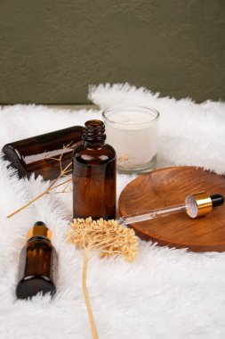 Doğal kozmetik şişeleri ve bir bardak gerekli yağlar..