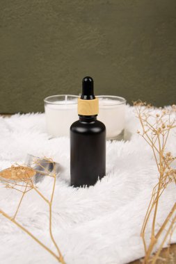 Temel yağ ve okaliptüs dallarına sahip şişe hafif arka planda, yakın plan.