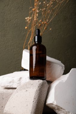 Doğal gövdeli doğal kozmetik şişeler ve gri arka planda doğal ürünler. Doğal güzellik, spa konsepti, cilt bakımı.