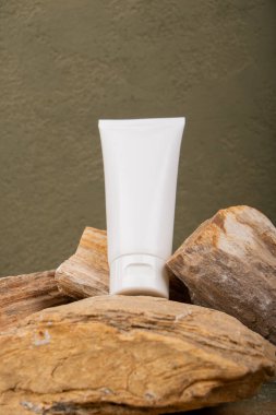 Kahverengi ahşap arka planda beyaz krema tüpü.
