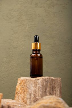 Tahta masanın üzerinde kahverengi bir şişe doğal yağ var. Metin için boşluk.