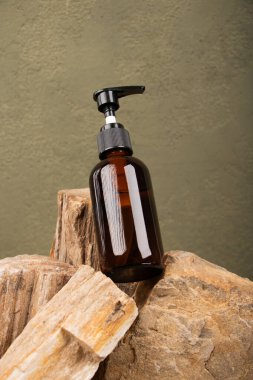 Siyah arka planda bir şişe temel yağ ve taze tropikal yaprak var. Metin için boşluk