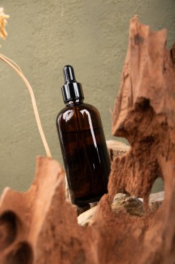 Bir şişe parfüm ve kurutulmuş çiçekler ahşap bir arka planda fotokopi alanı ile birlikte. Doğal güzellik ve cilt bakımı