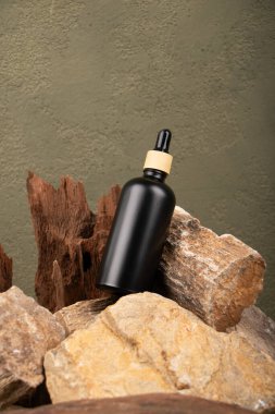 Yağlı siyah şişe, ürün için boş etiket ya da doğal gölgeli kahverengi ahşap arka planda etiket